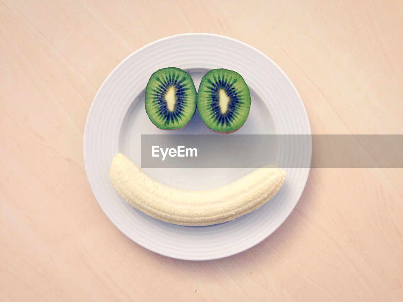 High angle view of banana and kiwi in plate on table