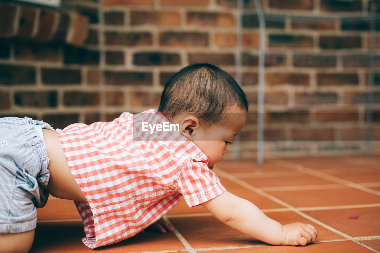 Cute baby boy on floor at home