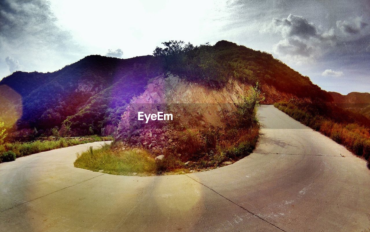 Winding road on mountain against sky