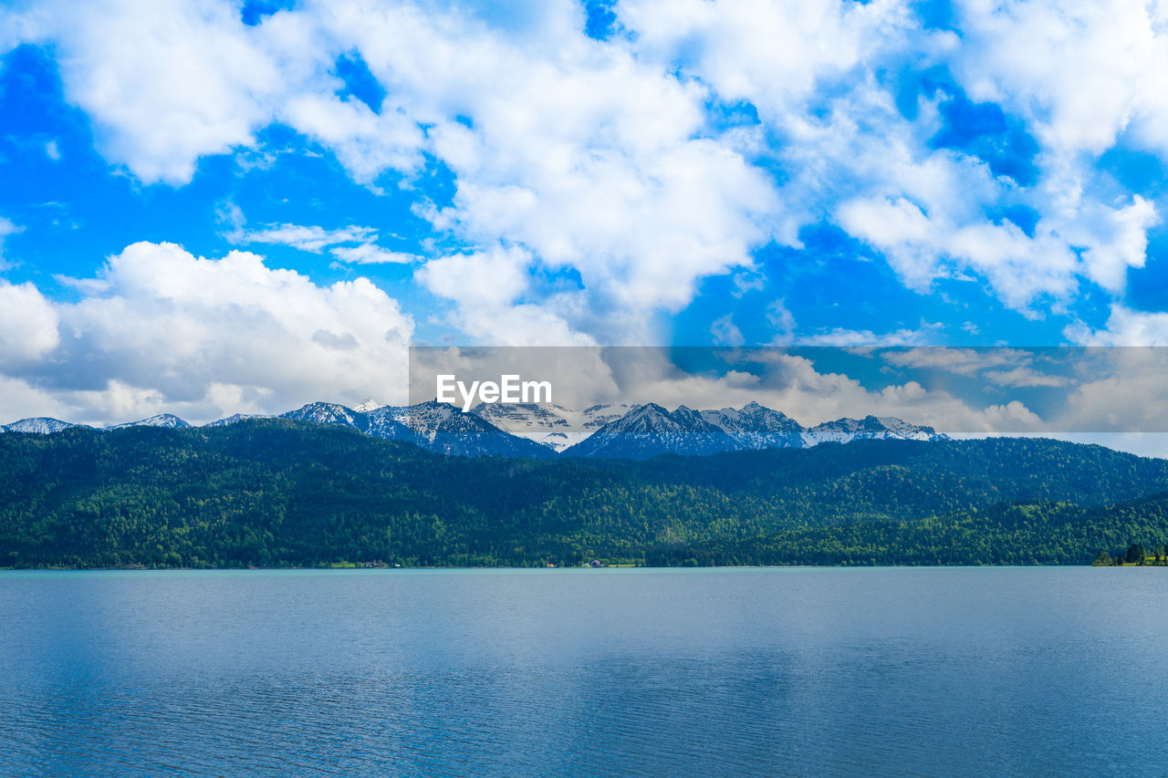 Scenic view of lake by mountains against sky