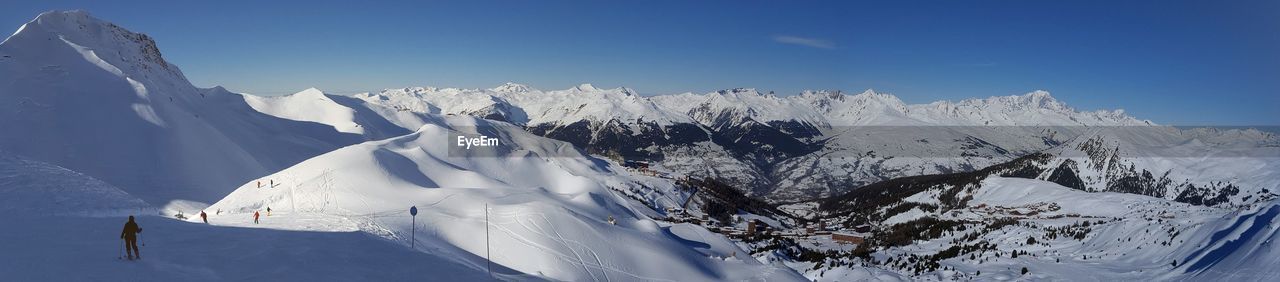 Scenic view of snowcapped mountain against blue sky