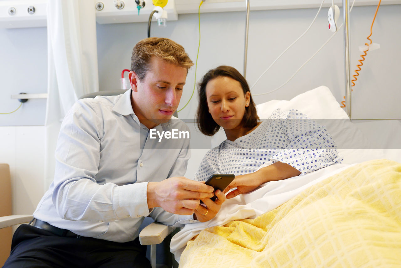 Couple using mobile phone at hospital