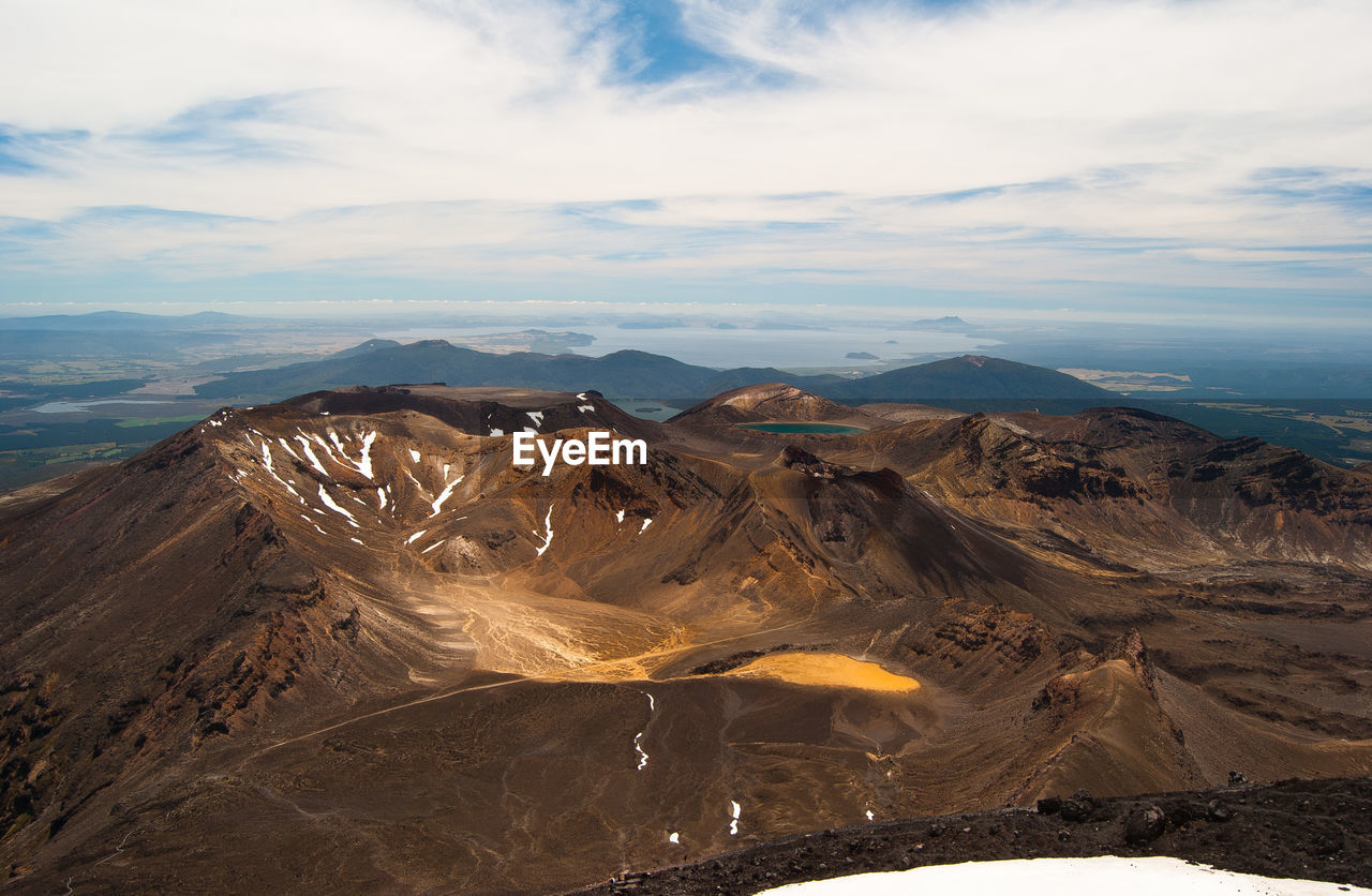 High angle view of volcanic landscape against cloudy sky