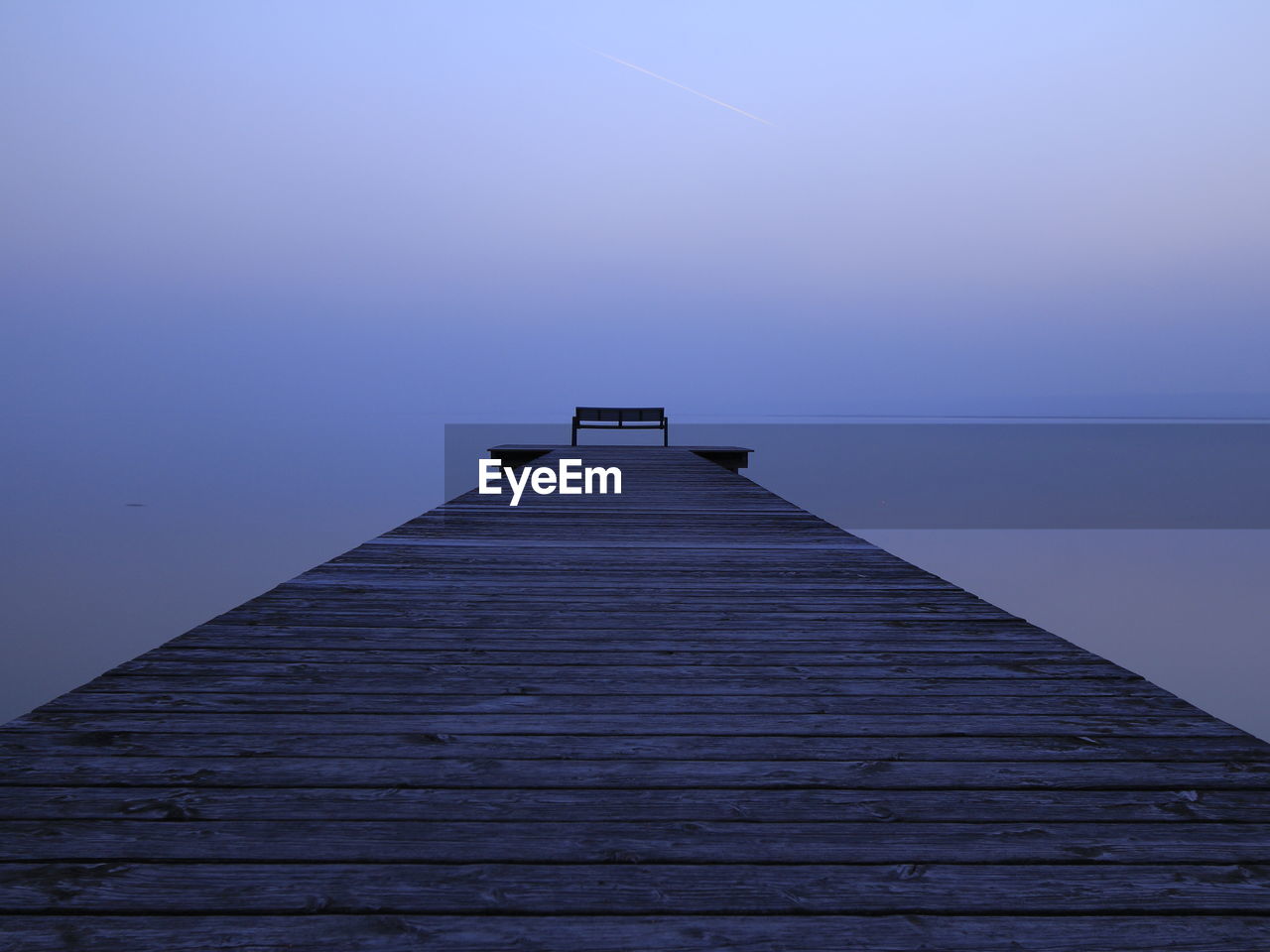 Wooden pier on sea against sky during sunset