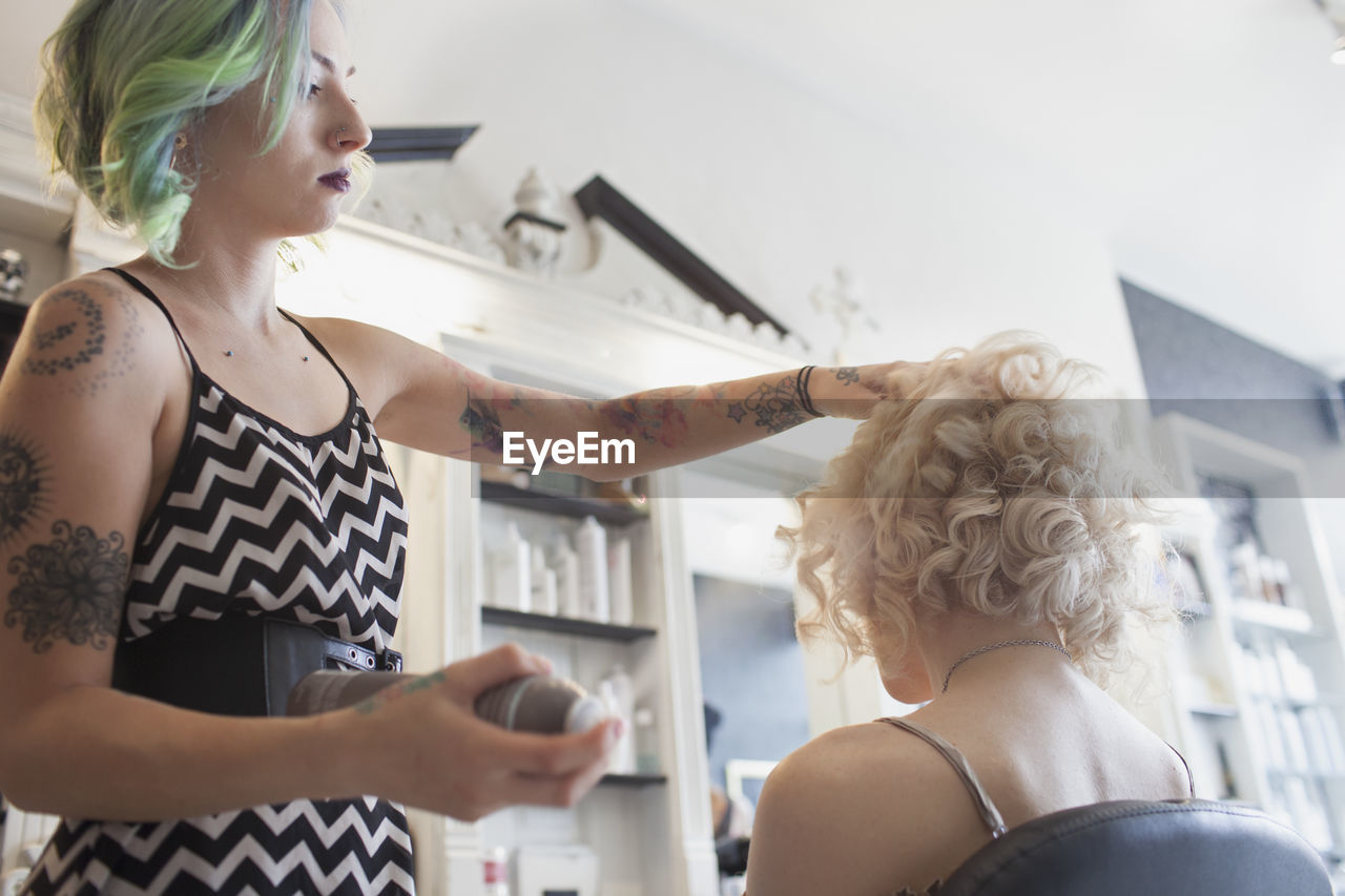 A hair dresser styling a customer's hair.