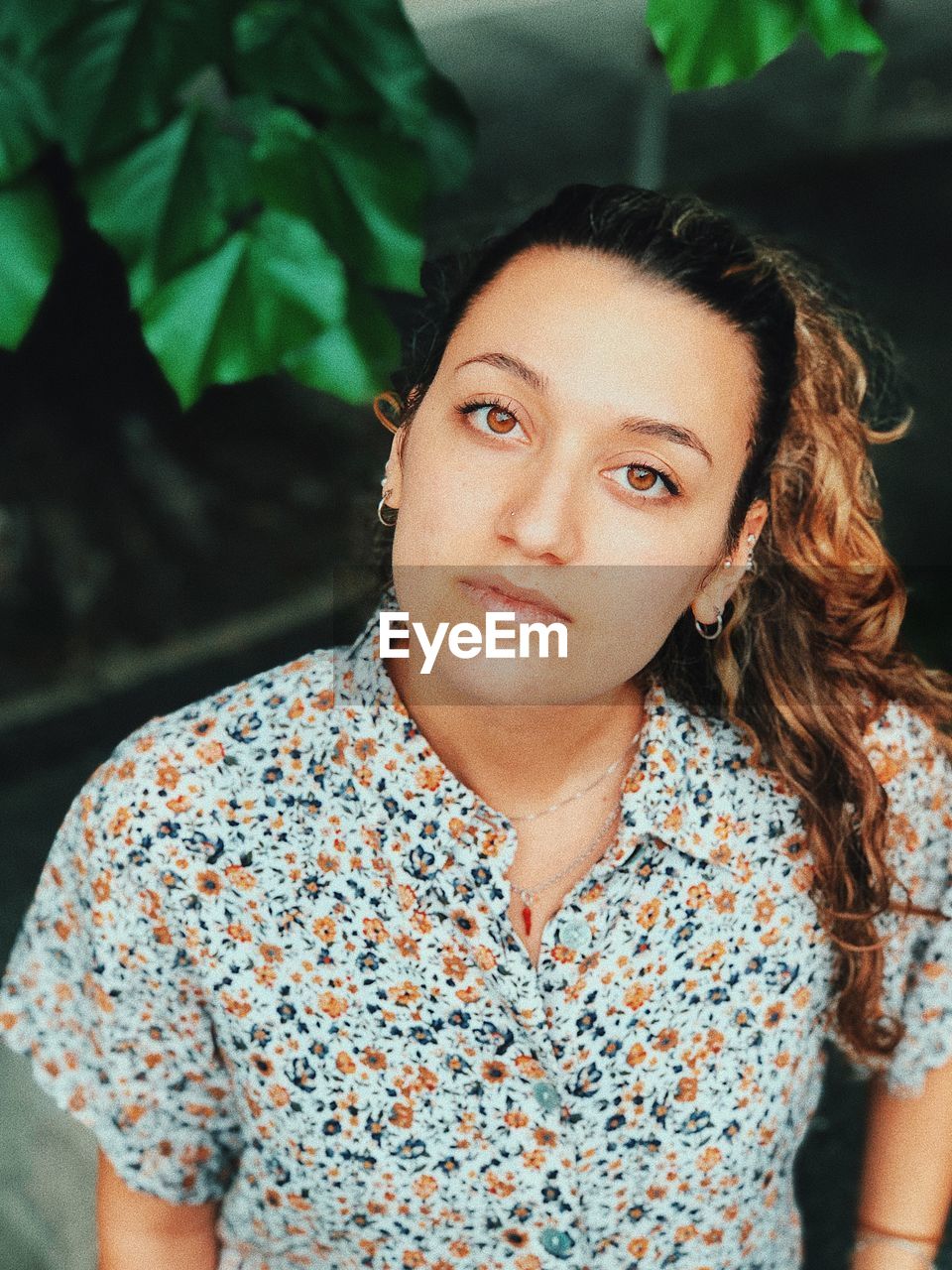 Close-up portrait of young woman against plants