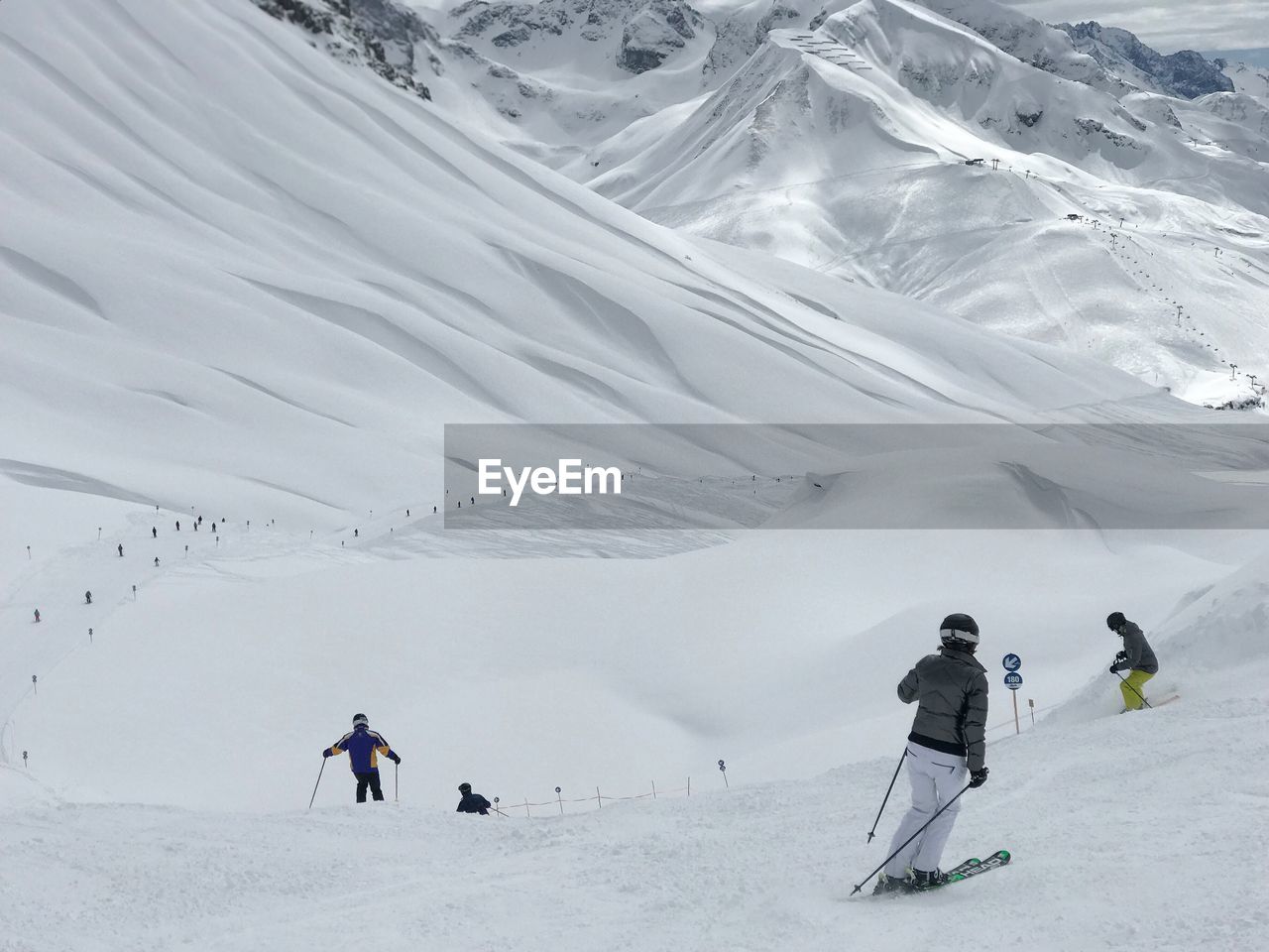 People skiing on snowcapped mountain in lech