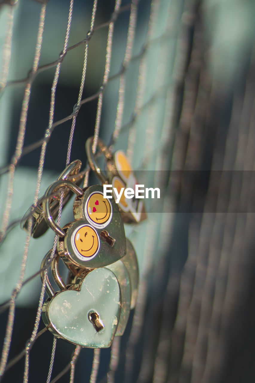 CLOSE-UP OF METAL HANGING ON FENCE