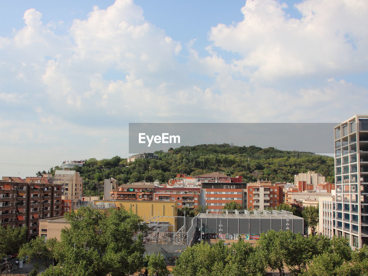 HIGH ANGLE VIEW OF TOWNSCAPE BY TREES AGAINST SKY