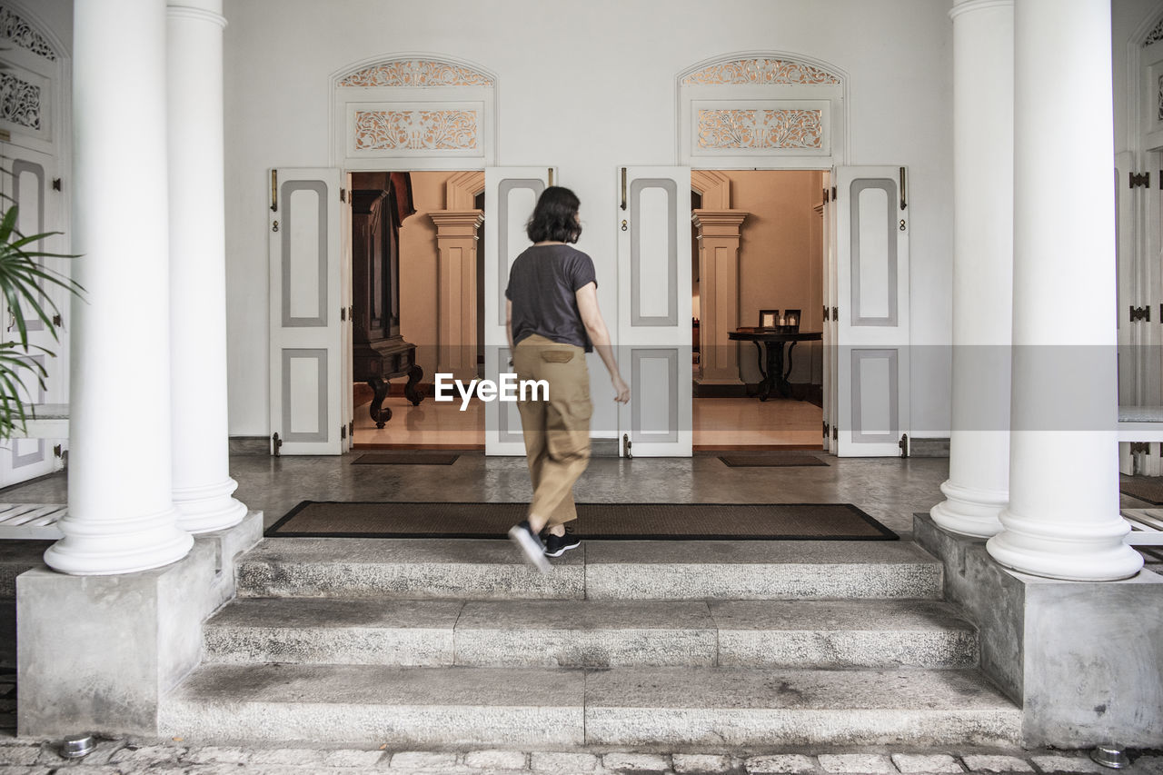 Woman walking into manour house style boutique hotel in colombo