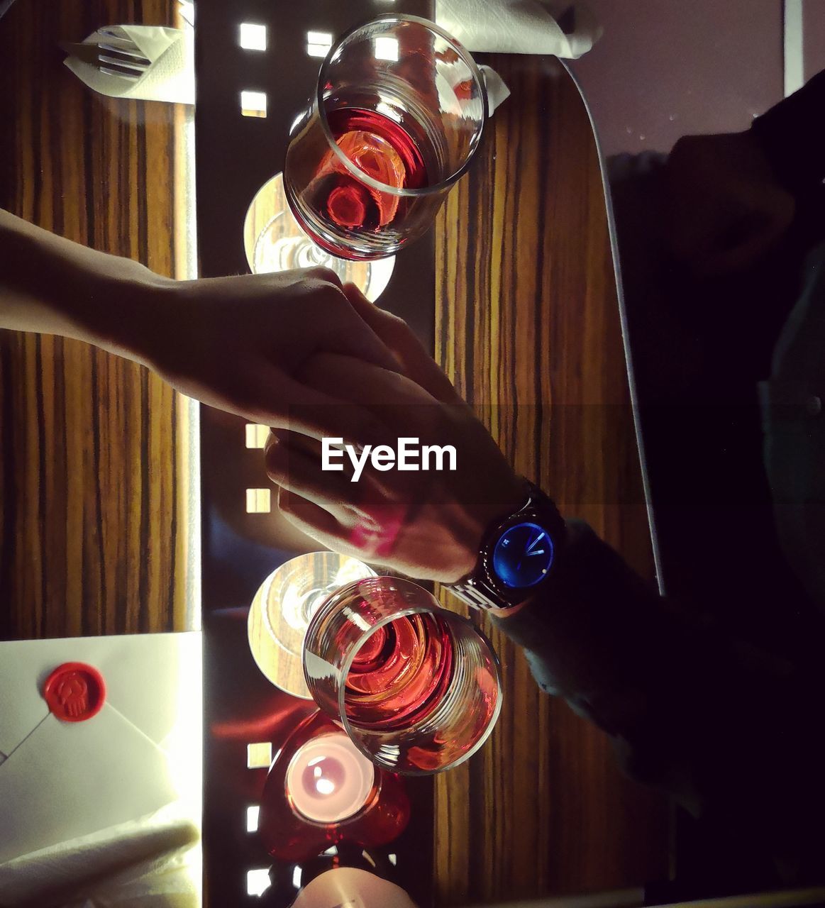 MIDSECTION OF WOMAN DRINKING GLASS ON TABLE AT HOME