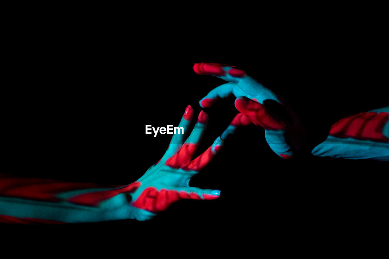 Close-up of two hands against black background