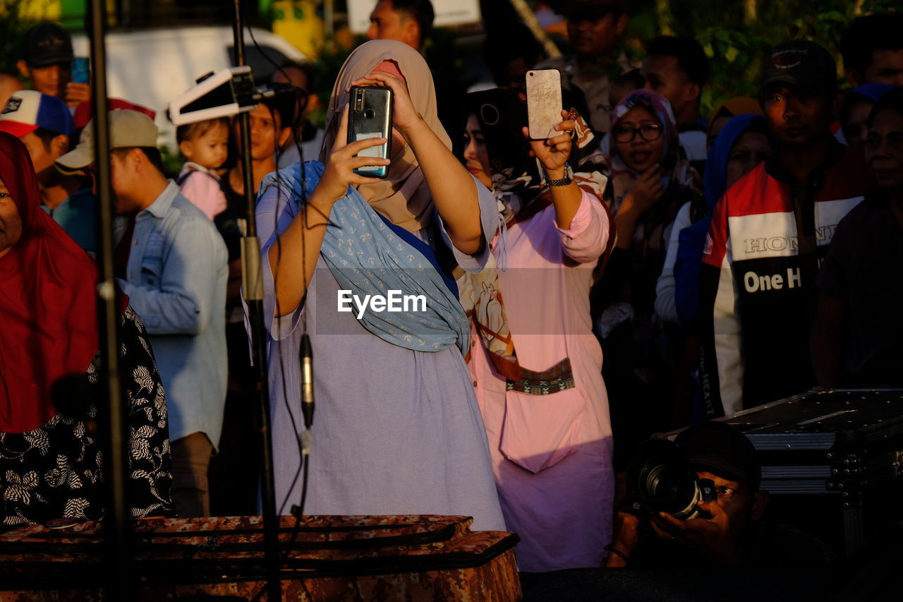 GROUP OF PEOPLE PHOTOGRAPHING ON STAGE