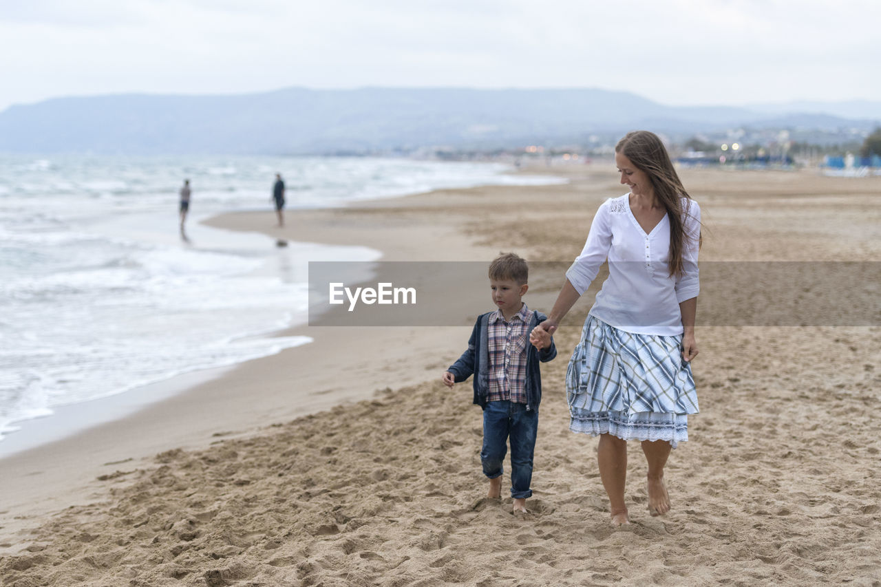 Mother and son walking at beach