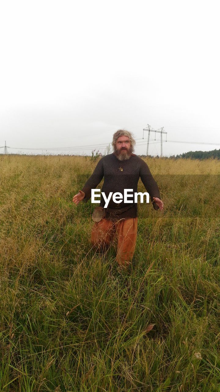 WOMAN ON FIELD AGAINST SKY