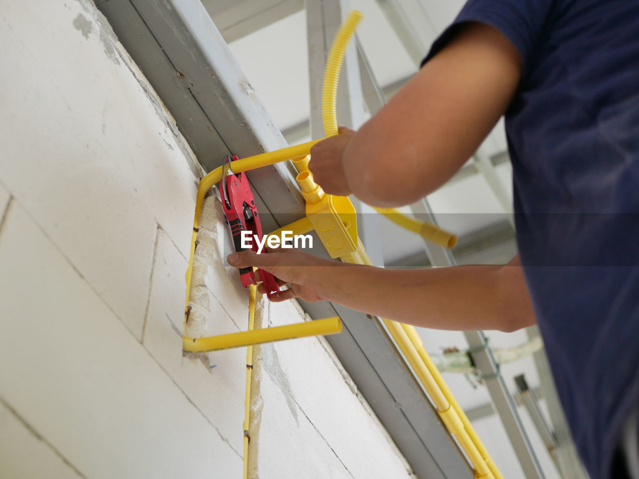 Cutting pvc pipe, during electrical system installation, using a cutter for electrical conduit