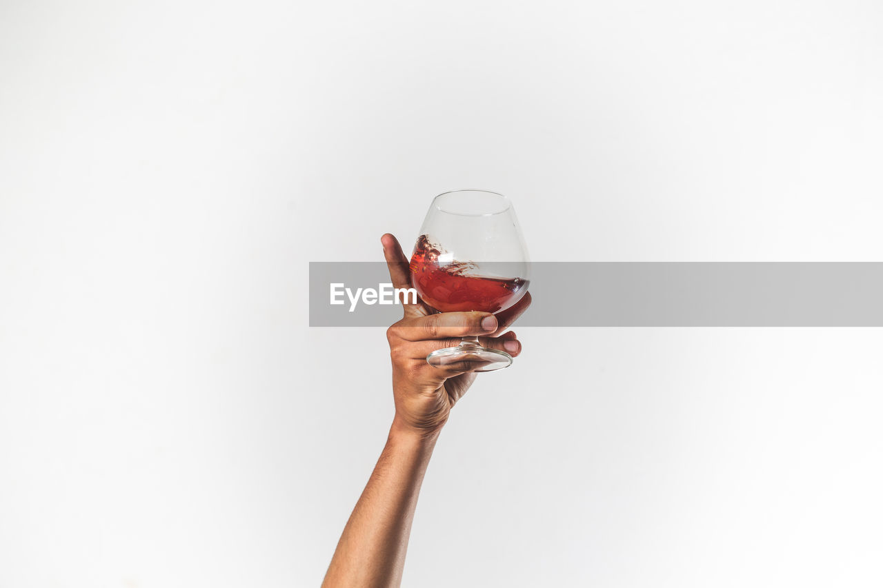 Hand holding glass of wine isolated - celebration concept