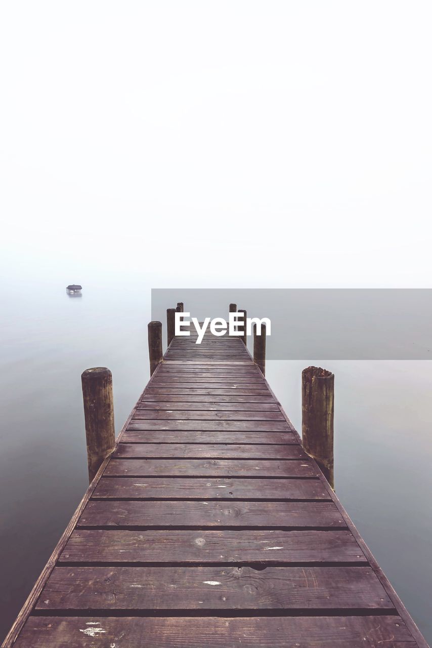 Wooden pier over sea against sky