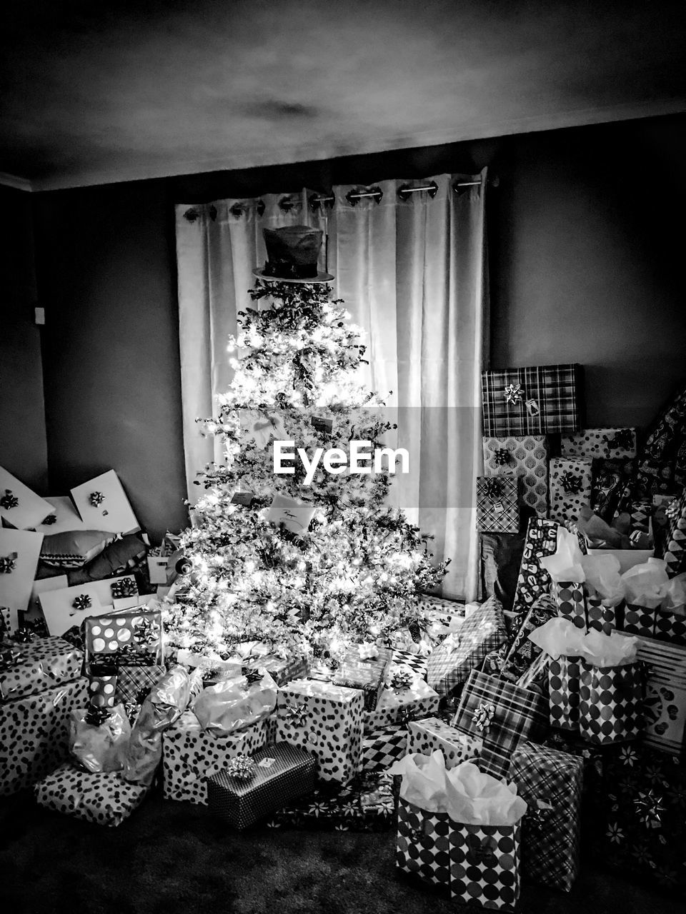 Illuminated christmas tree and gift boxes at home