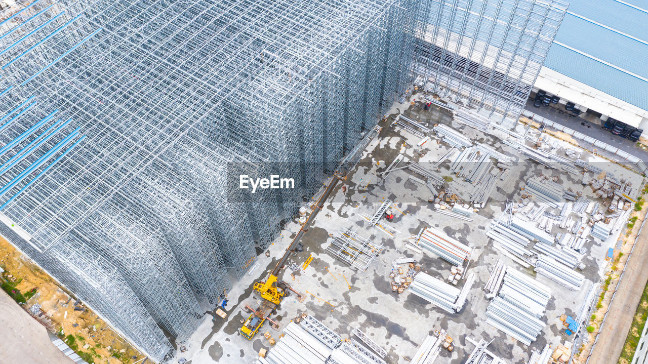 HIGH ANGLE VIEW OF CARS ON ROAD AMIDST BUILDINGS