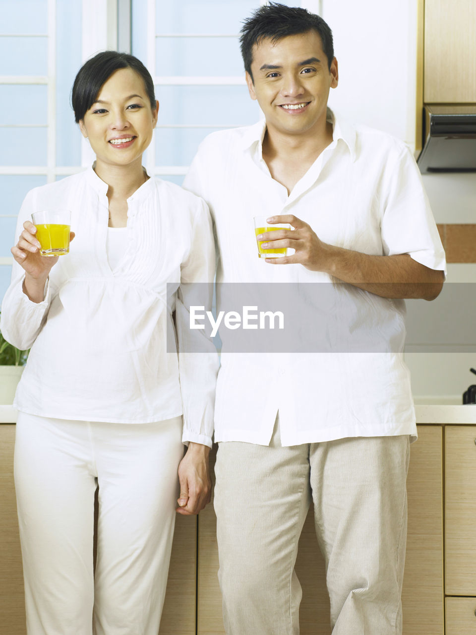 Portrait of couple having drink while standing at home