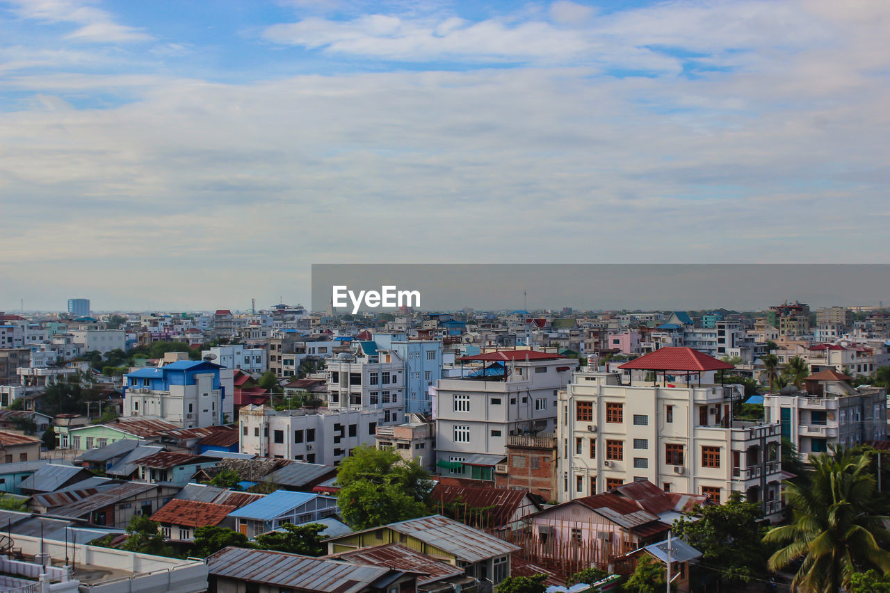 HIGH ANGLE VIEW OF CITYSCAPE AGAINST SKY