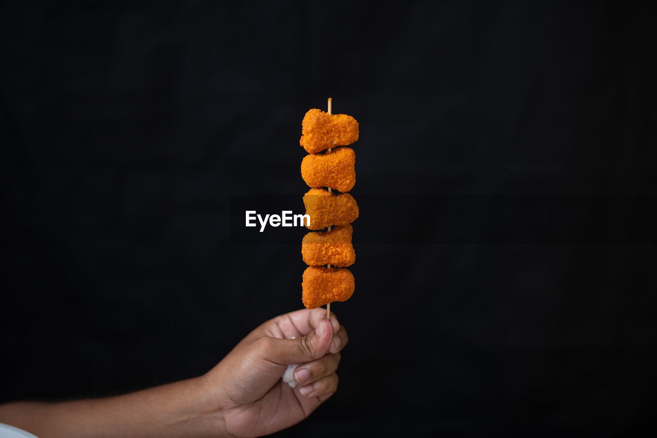 CLOSE-UP OF HAND HOLDING BREAD