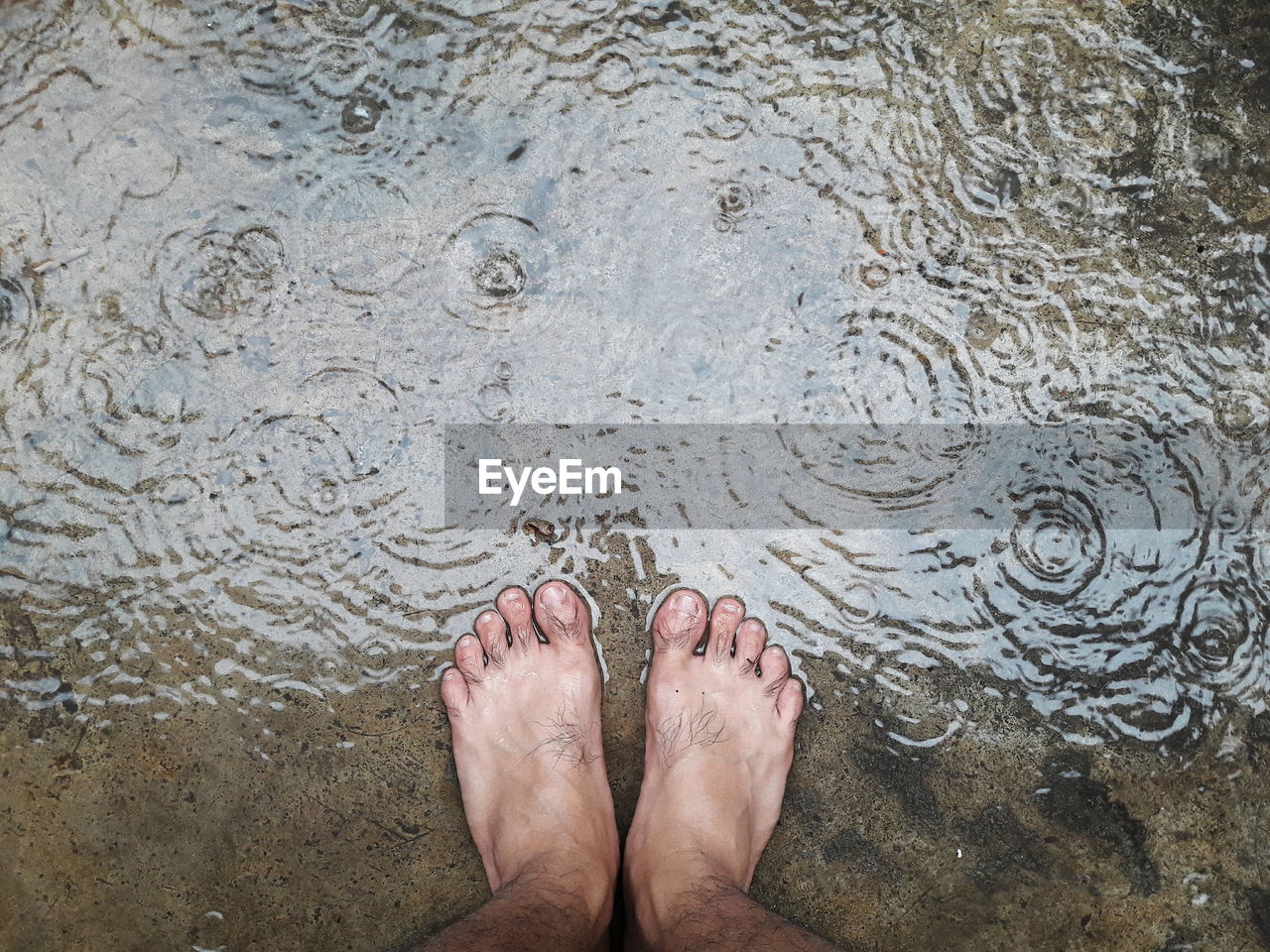 LOW SECTION OF WOMAN STANDING BY WATER