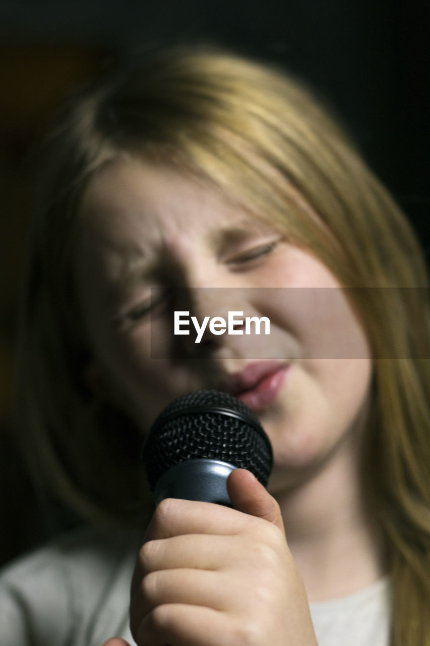 Girl holding microphone and singing