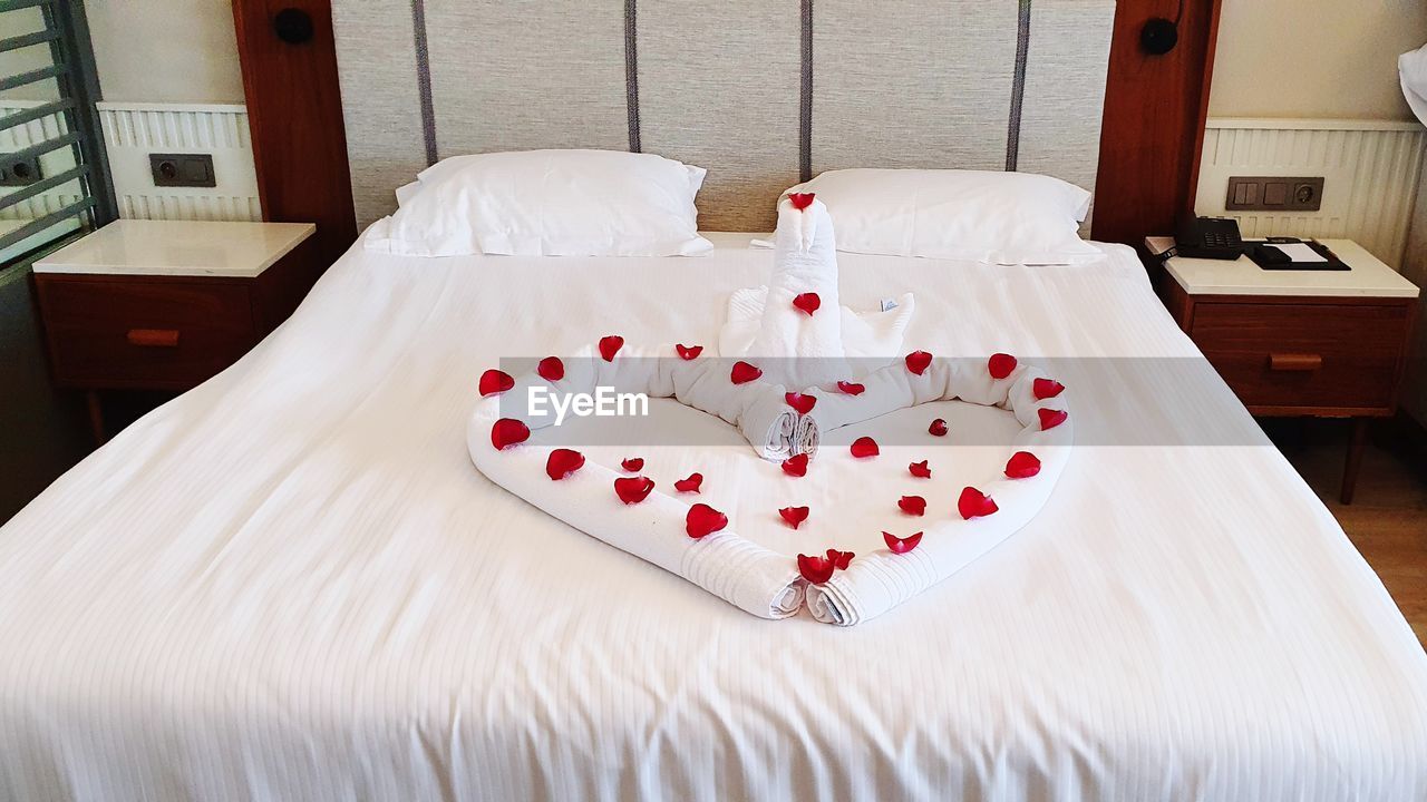 bed, furniture, indoors, bedroom, love, domestic room, bed sheet, room, relaxation, no people, white, heart shape, sheet, positive emotion, pillow, linen, duvet cover, home interior, mattress, lifestyles, hotel room, red, wealth