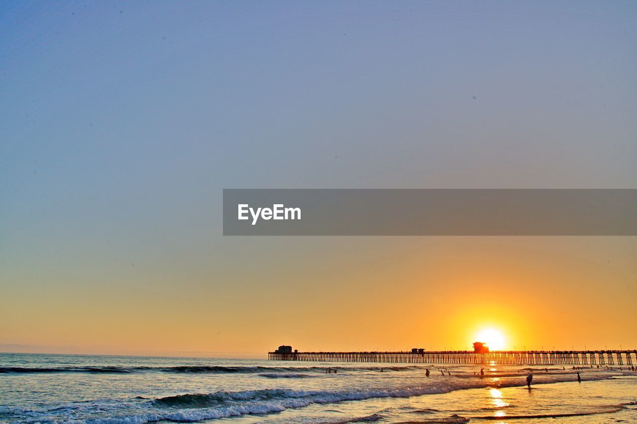 Scenic view of sea against clear sky during sunset