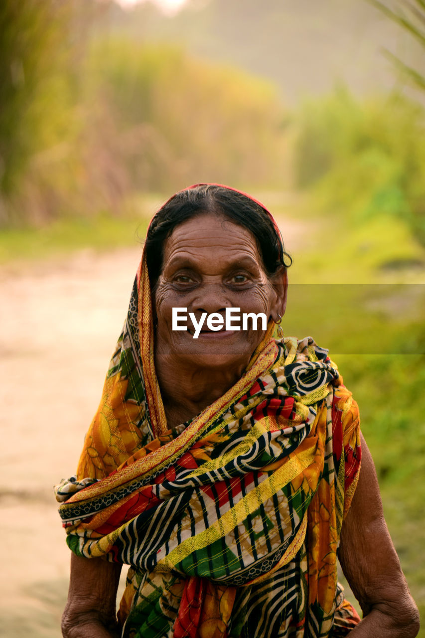 Portrait of smiling senior woman wearing sari standing outdoors