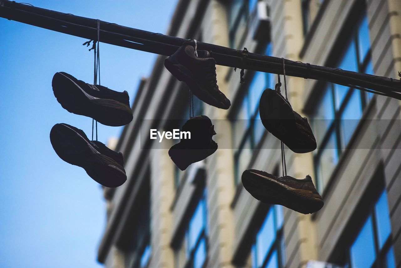 Low angle view of shoes hanging by building