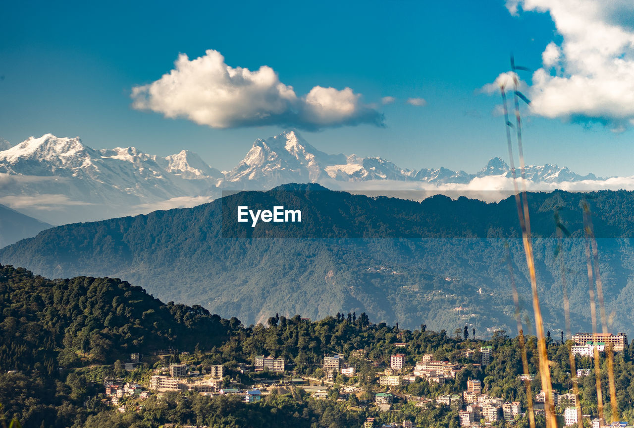 Panoramic view of townscape and mountains against sky