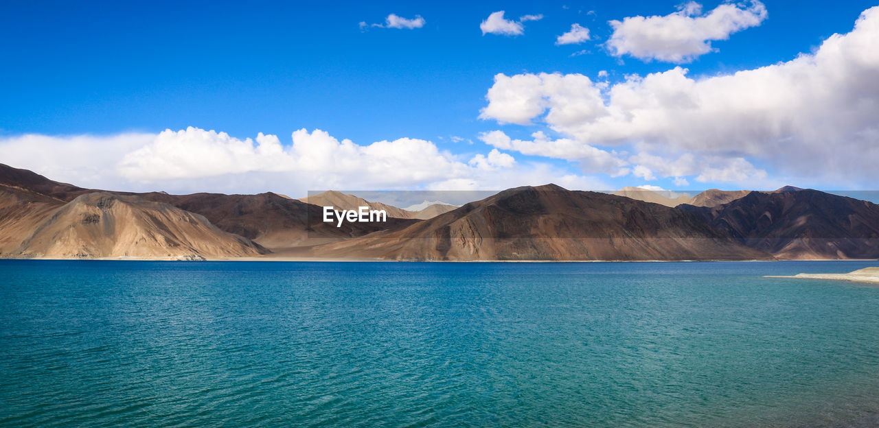 Panoramic view of mountains against blue sky