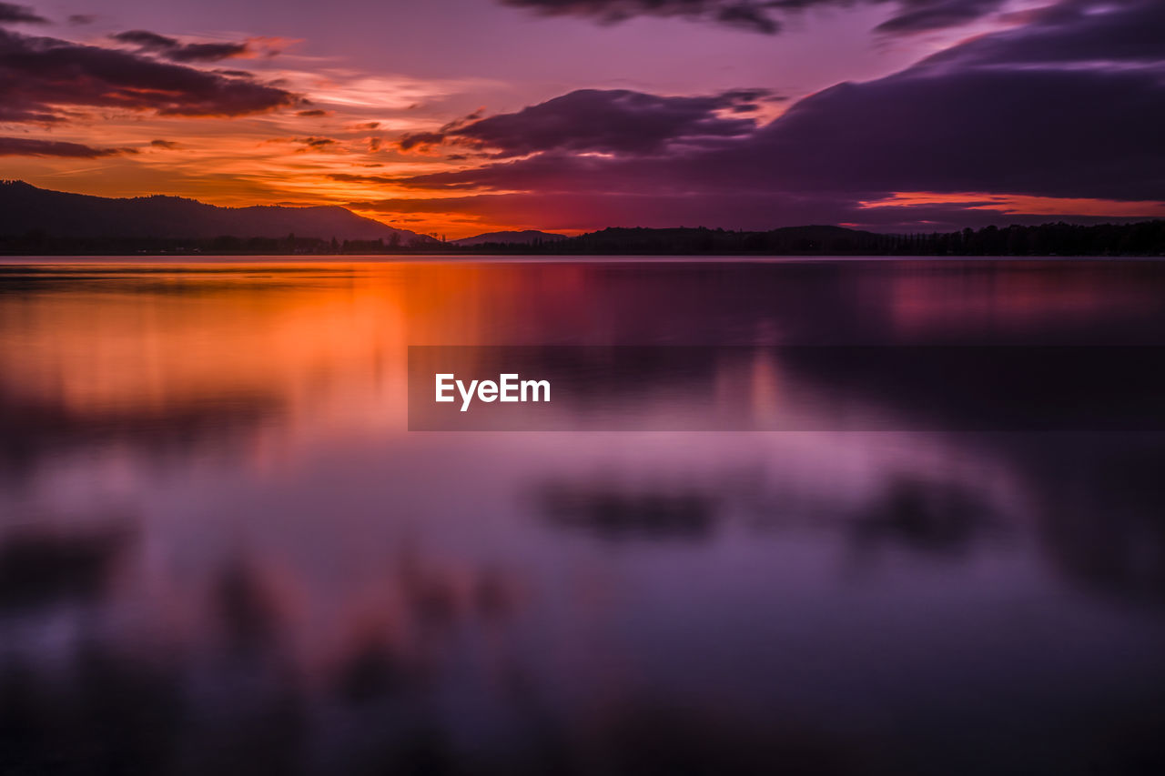 Scenic view of lake against romantic sky at sunset