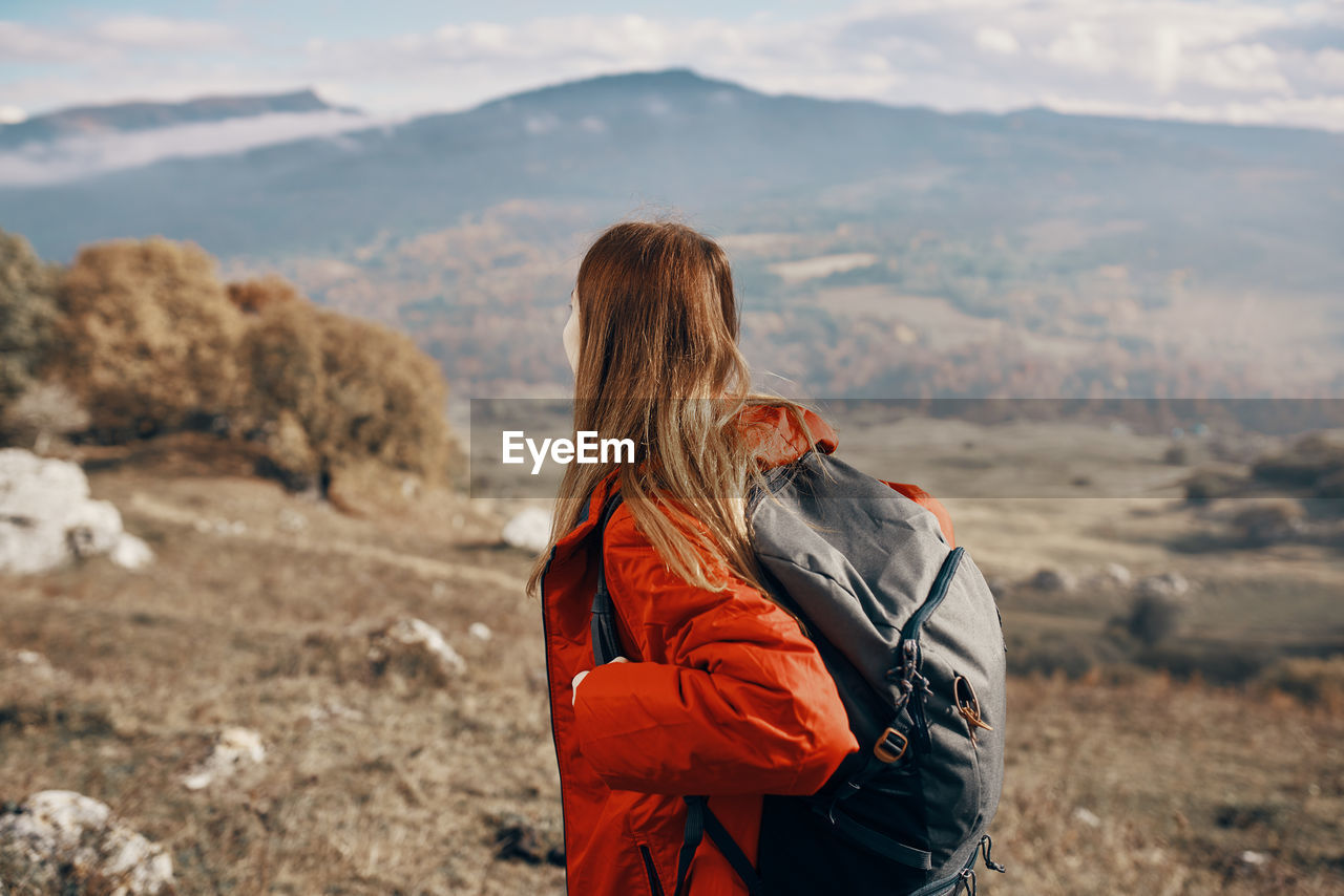Side view of woman looking at mountain range