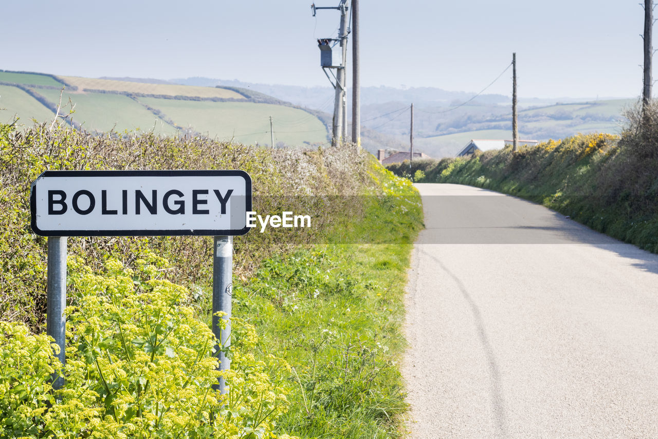 ROAD SIGN BY TREES ON LANDSCAPE