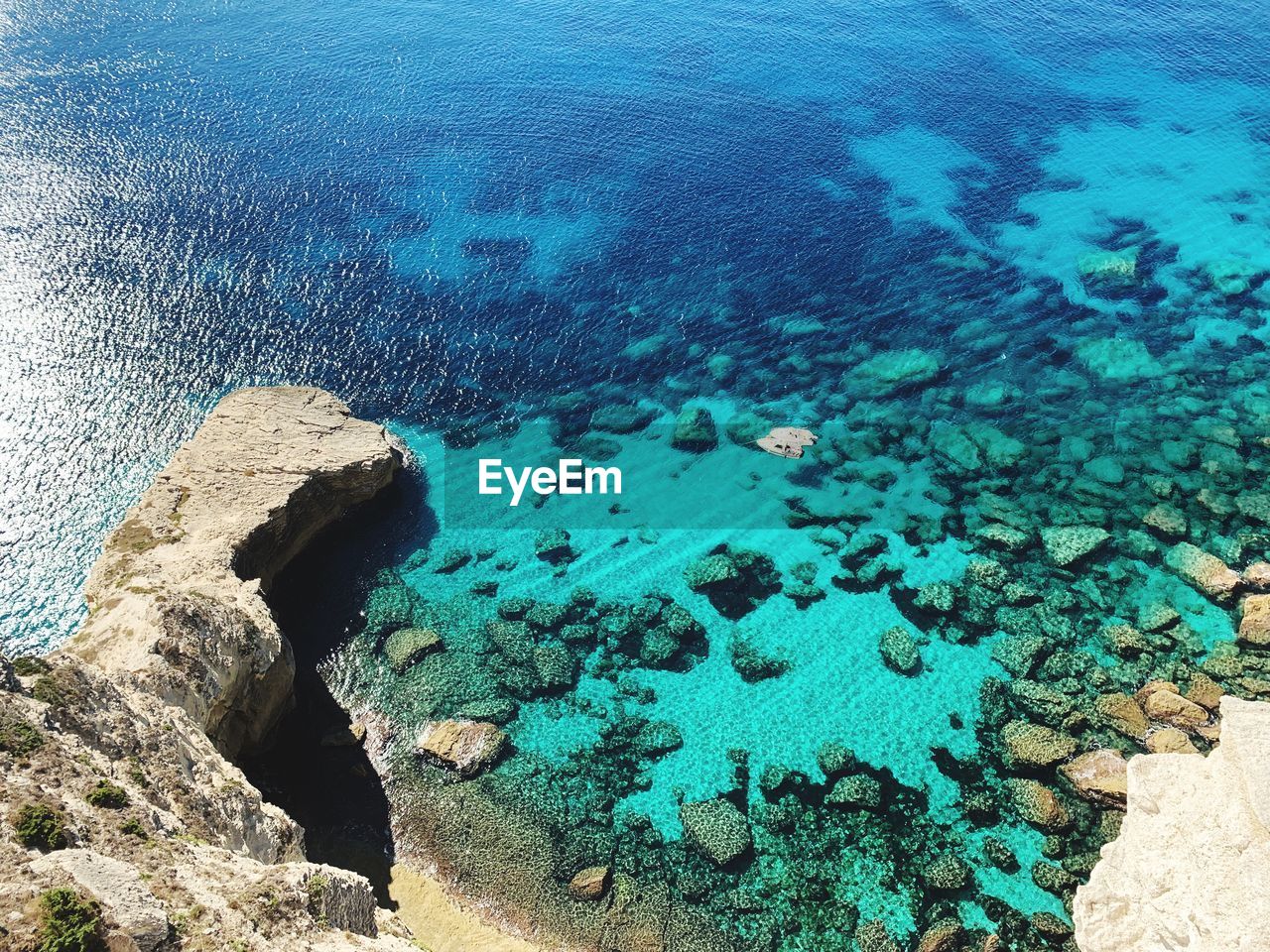 High angle view of rocks on sea shore