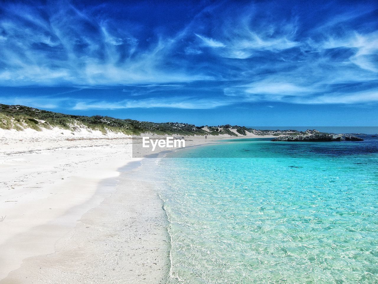 Scenic view of beach against blue sky