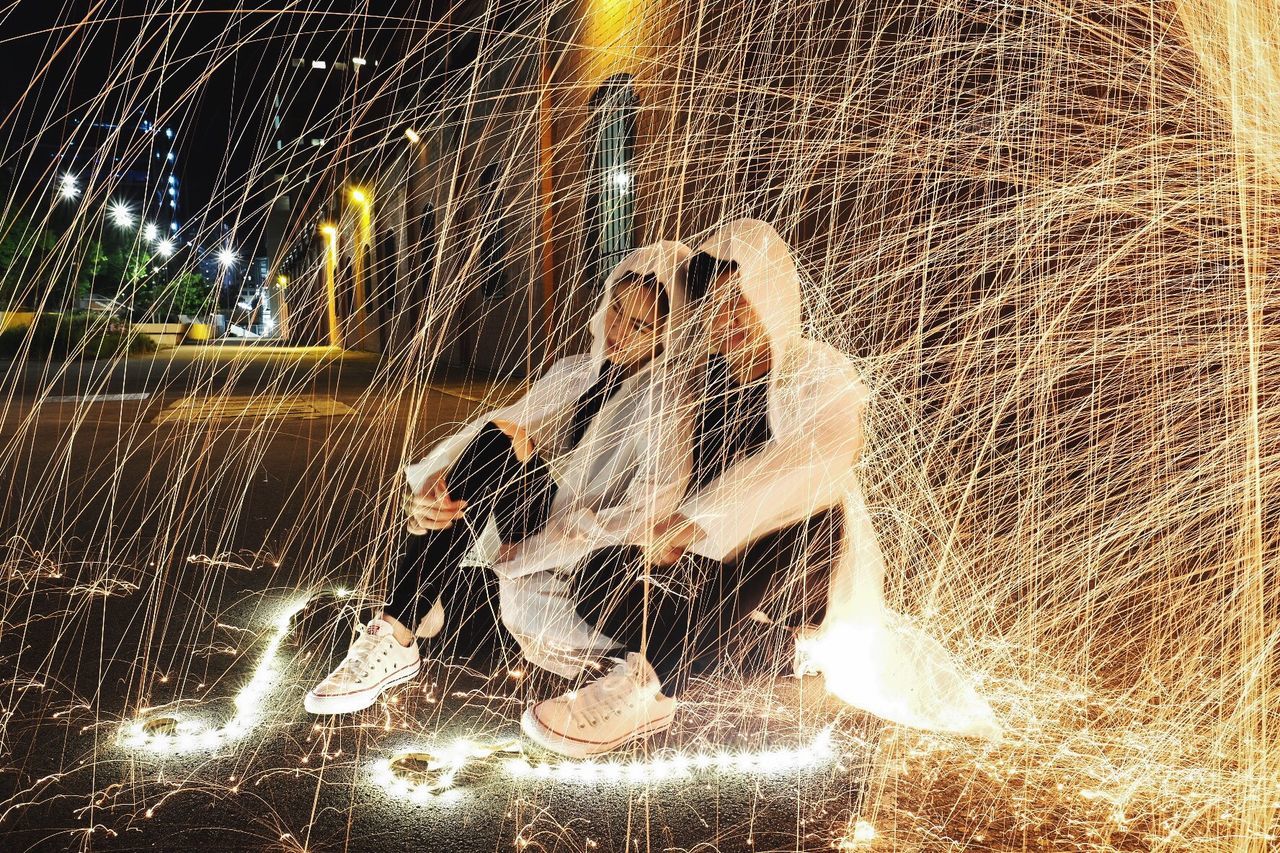 BLURRED MOTION OF WOMAN WITH ILLUMINATED LIGHTS