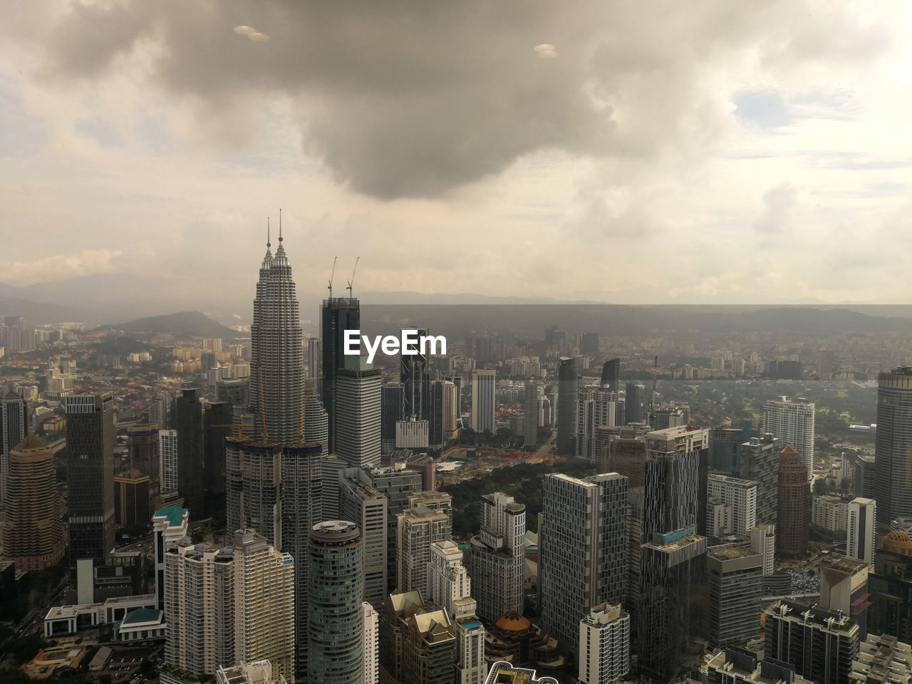 MODERN BUILDINGS IN CITY AGAINST CLOUDY SKY