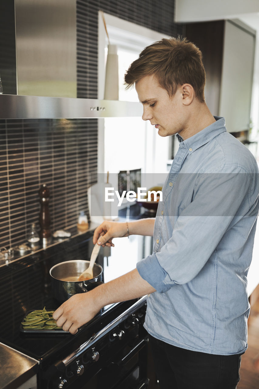 Young man preparing food in kitchen