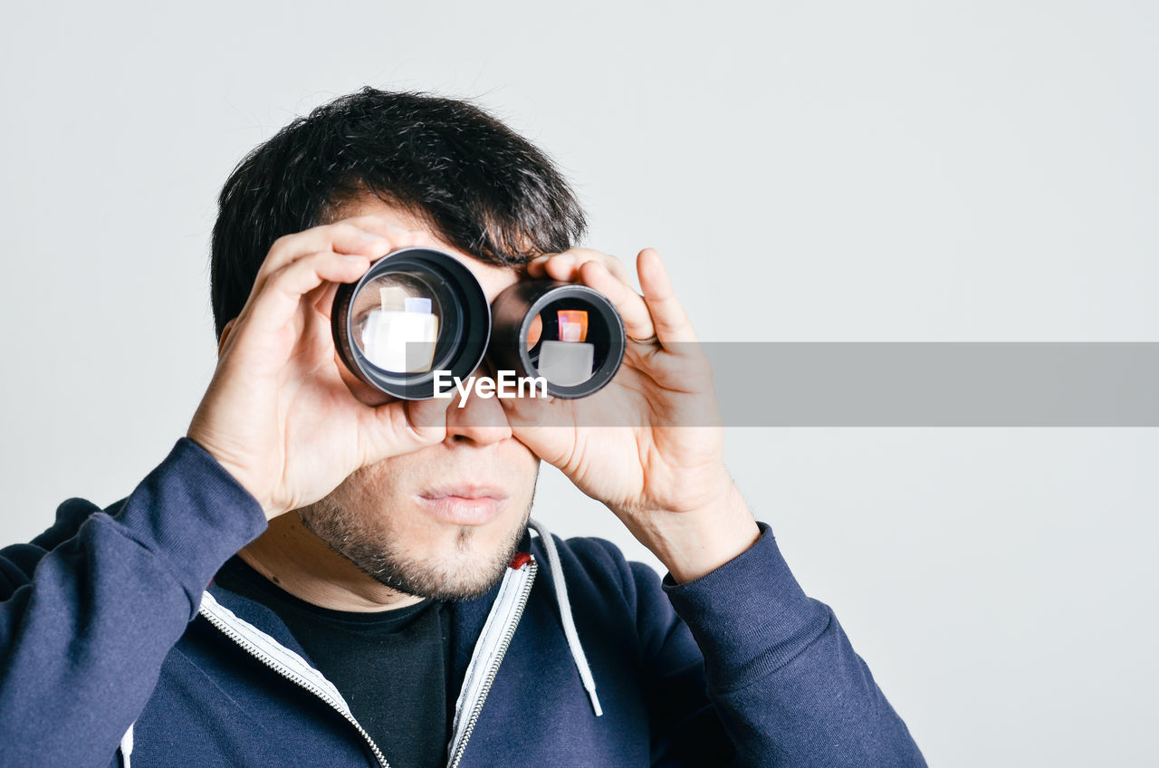 Portrait of man looking through lenses