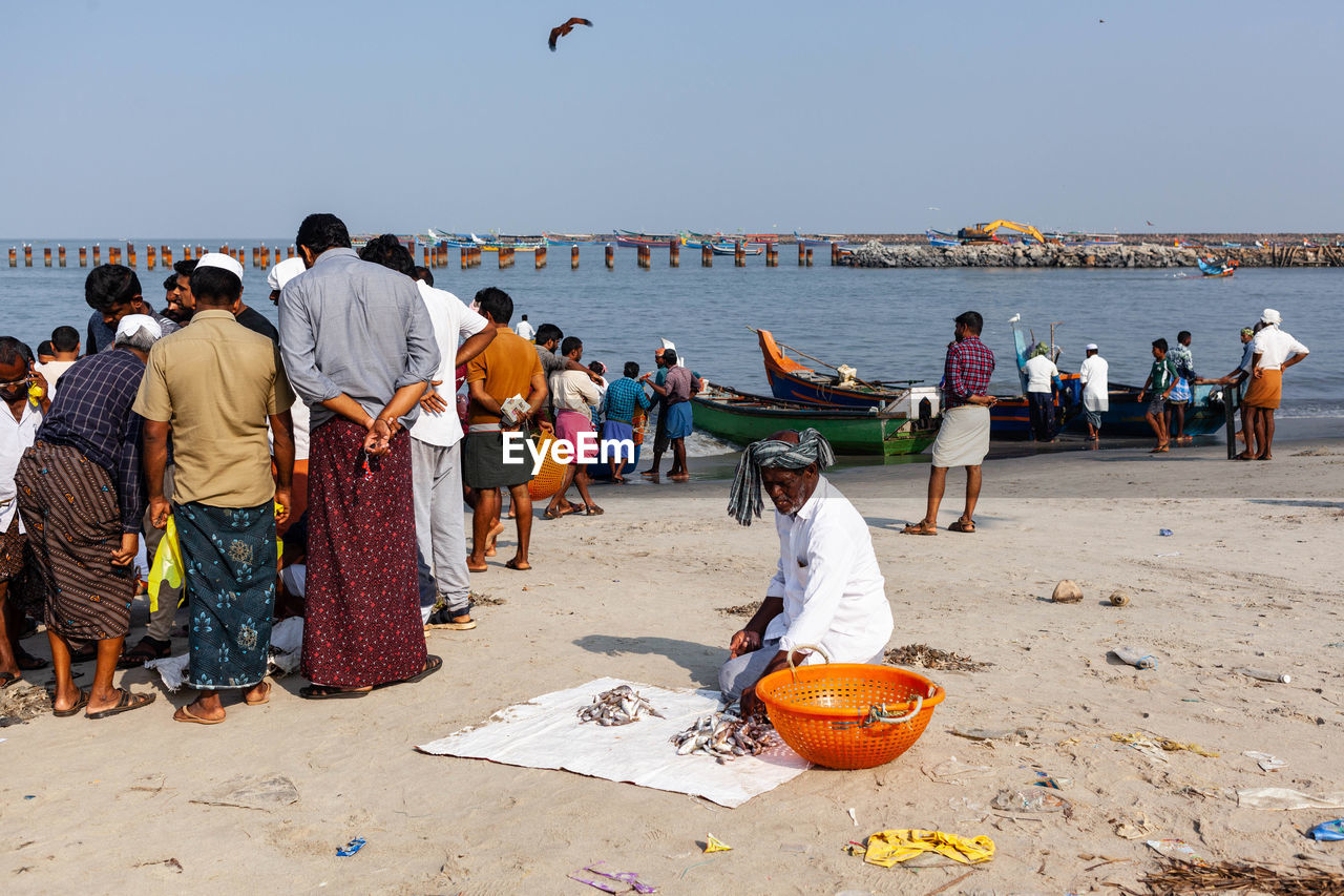 PEOPLE AT BEACH AGAINST SKY