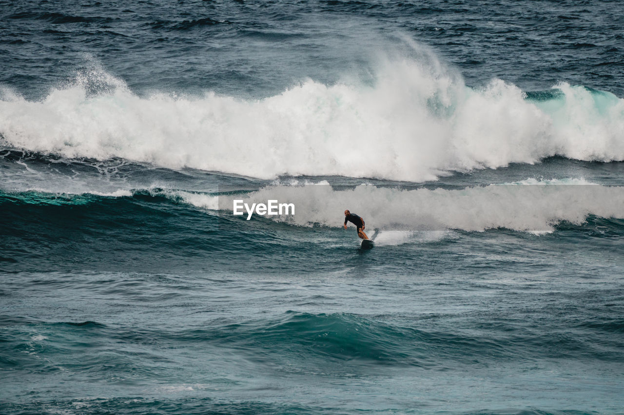 Man surfing waves in atlantic ocean, tenerife, spain