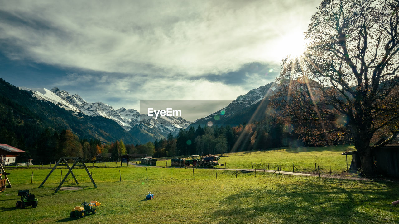 SCENIC VIEW OF FIELD AND MOUNTAIN AGAINST SKY