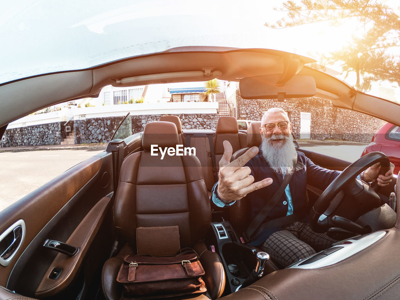 Hipster stylish man inside convertible car - focus on face