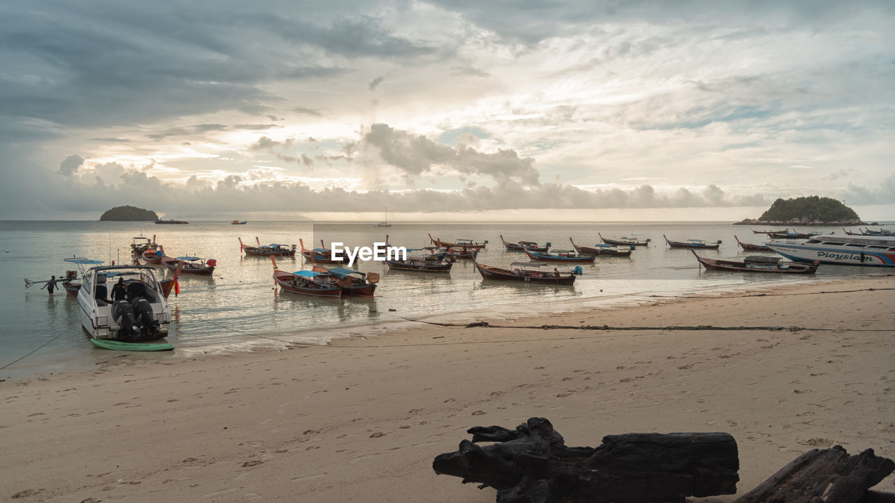 BOATS ON BEACH AGAINST SKY DURING SUNSET