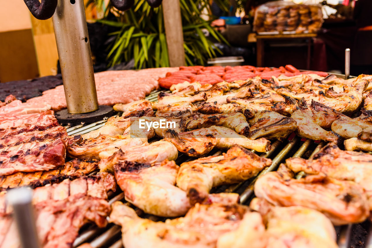 CLOSE-UP OF MEAT COOKING ON BARBECUE